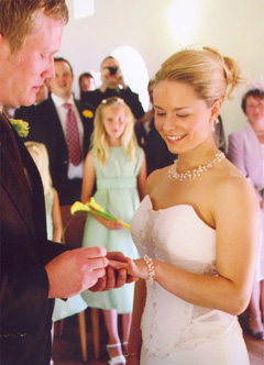 Groom fitting ring on bride