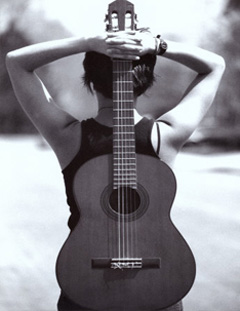 Acoustic guitar behind women's back